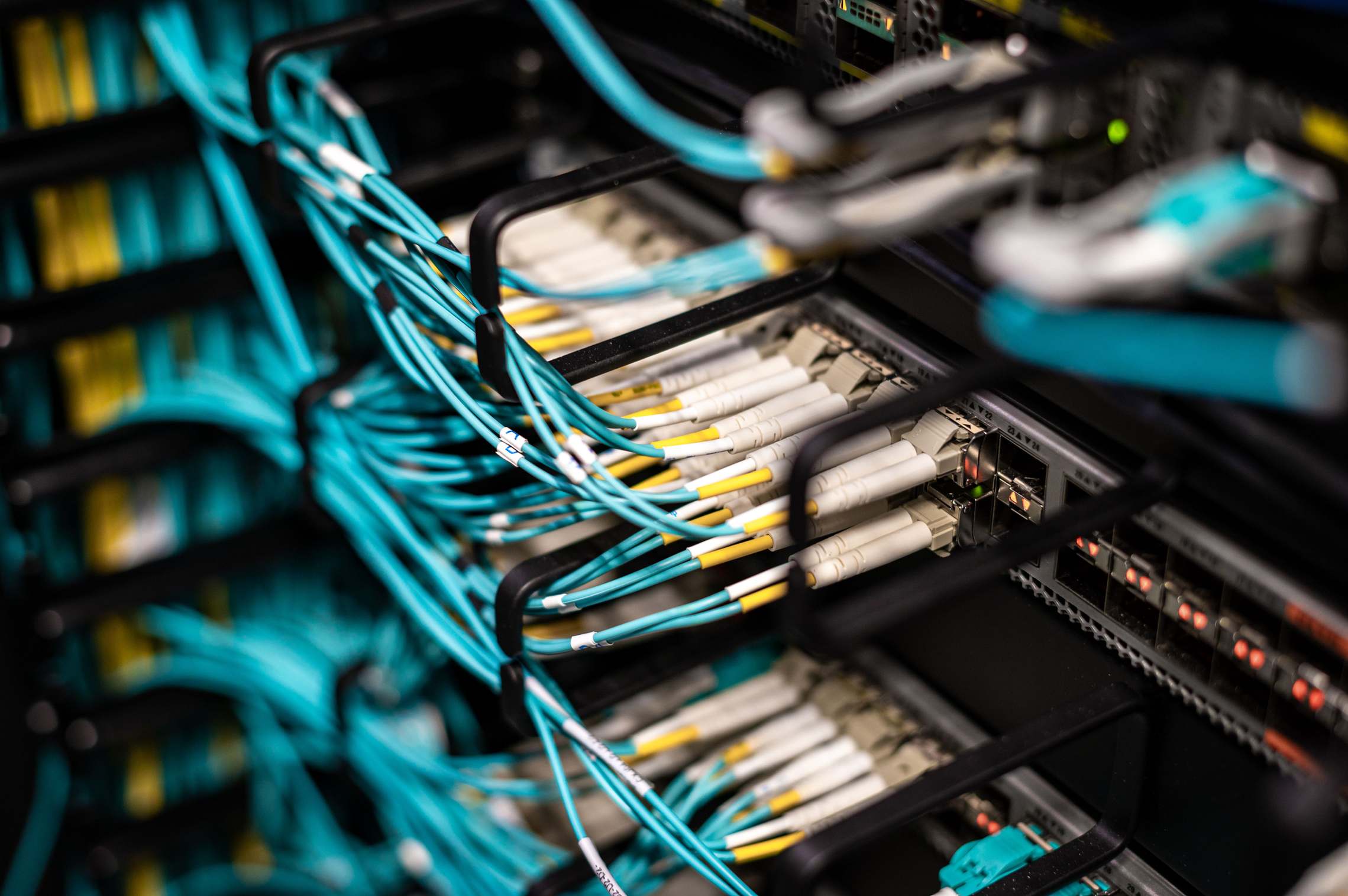 Server room with network equipment lit at night, cables in a data center patch panel